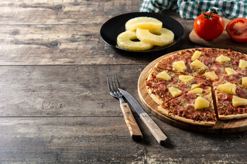 Hawaiian pizza with pineapple,ham and cheese on wooden table	