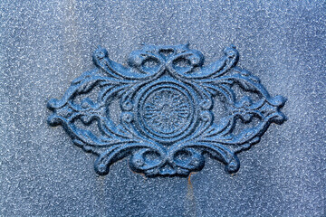 Ornament on iron surface. Coated surface that looks like dust.