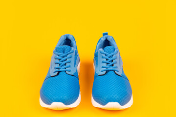 pair of comfortable blue sport shoes on yellow background, sportswear