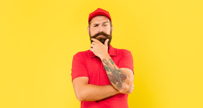 Pensive Man In Casual Red Cap And Tshirt Stroking Chin Yellow Background, Volunteer