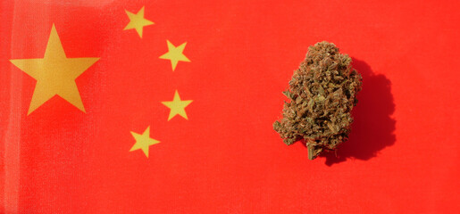 Cannabis bud lay on Chinese flag. Marijuana legalization banner 
