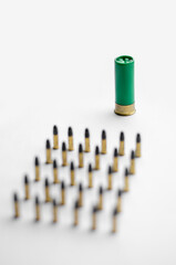 high angle view of blurred bullets near shotgun shell on white background.