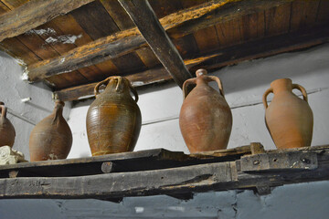 Fototapeta na wymiar ancient clay jugs for olive oil on wooden shelf, close-up