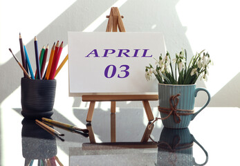 Calendar for the third of April: an easel with the inscription April in English and the numbers 03,...