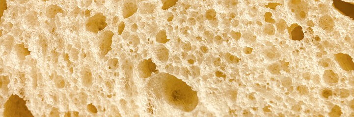 texture of white bread as a close up background. backdrop of rough dappled textured surface slice of loaf or sandwich dough of natural organic food with holes. top view. banner