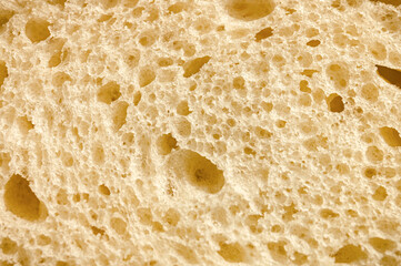 texture of white bread as a close up background. backdrop of rough dappled textured surface slice of loaf or sandwich dough of natural organic food with holes. top view