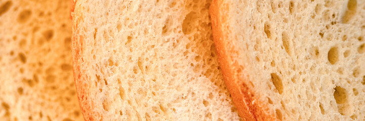 texture of slices white bread as a close up background. backdrop of rough dappled textured surface chopped pieces loaf of natural organic food with holes. top view. banner