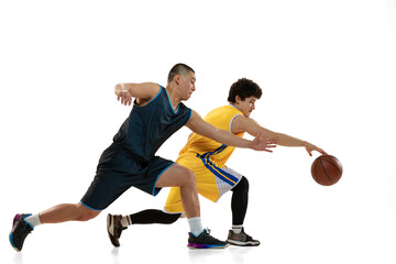 Dynamic portrait of two young basketball players playing basketball isolated on white studio background. Motion, activity, sport concepts.