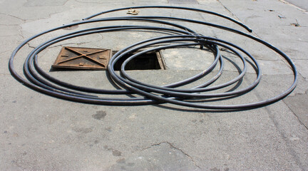 Long hose, open manhole and a pair of gloves - 496286107