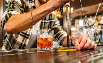 bartender stamping orange peel on the bar counter