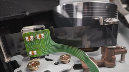 Running part pulls magnet tape to head of old videocassette recorder in room macro view. Vintage device to enjoy cinema at home. Technology service