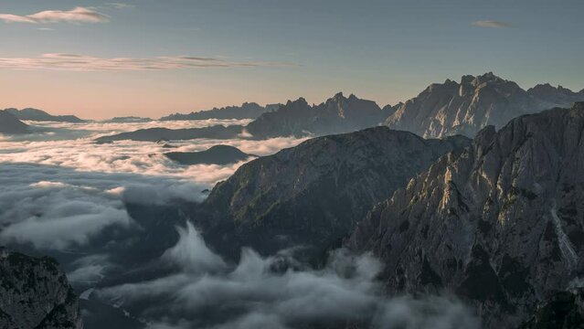 Timelapse of low inversion clouds between mountain layers during sunrise in the Dolomite Alps in South Tyrol, Italy
