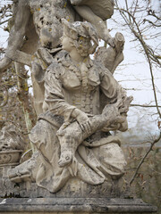 Fototapeta na wymiar Barocke Steinstatue einer Jägerin mit erlegtem Wild im Schloßgarten Veitshöchheim (Bayern, Deutschland)