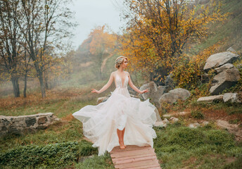 Fantasy woman elf in white creative design vintage dress walks in autumn nature, yellow foliage...