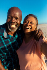 Portrait of happy retired african american senior couple enjoying together at beach