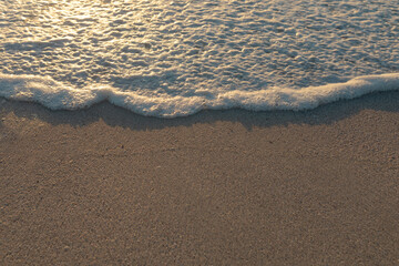 High angle view of wave foam on shore sand at beach during sunset