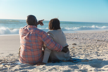 Rear view of african american senior couple spending leisure time together at beach