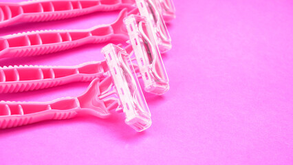 New pink disposable razors for safe shaving of female skin.Razor for smooth shaving. Sharp razors for personal hygienic routine. selective focus.
