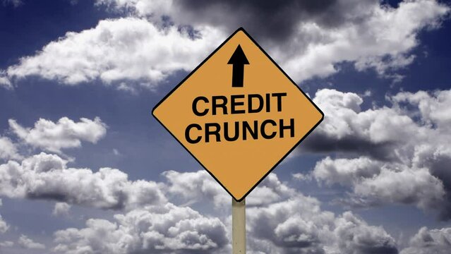 Money credit and financial problems. Zoom in to a Credit Crunch road sign with time lapse clouds background.