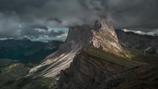 Timelaspe of dramatic mountain peaks of Seceda with clouds in the European Dolomite Alps, meadow in the foreground, steep cliff, South Tyrol Italy
