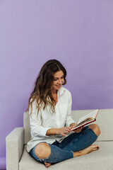 beautiful woman reading educational book on couch