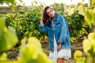 a beautiful woman picks berries in a vineyard