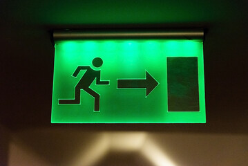 Green fire escape sign hang on the ceiling