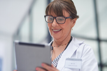 Live appointments have been a brilliant work around. Shot of a mature female doctor using a tablet.