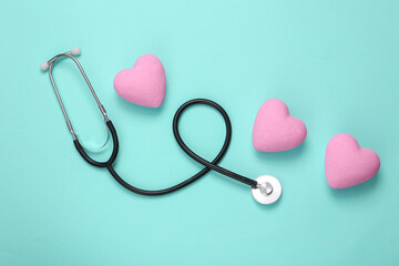 Stethoscope with hearts on a turquoise background. Love or medical flat lay still life