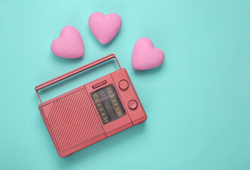 Retro fm radio receiver with hearts on blue background. Romantic melody. Top view