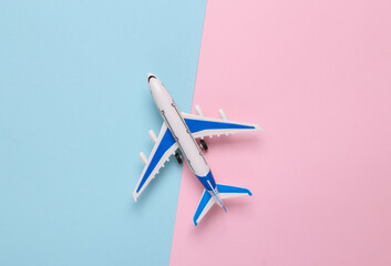 Toy model airplane on a blue-pink background. Travel concept. Flat lay, top view