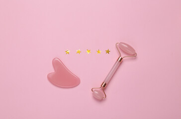 Excellent beauty service. Jade massage roller with guasha ston with 5 gold stars on pink background. Top view