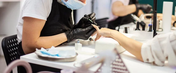 Tuinposter Manicure Manicure-workflow met de nagels van de klant. Nagelverzorging, manicure
