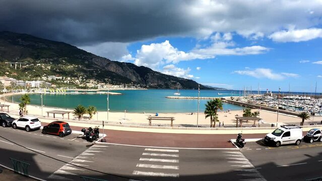 Menton, France, October 6, 2021: PAN SLOW MOTION SHOT - Sablettes beach in Menton is located between the two ports (the Old Port and Garavan), along the Quai Bonaparte and the old town.
