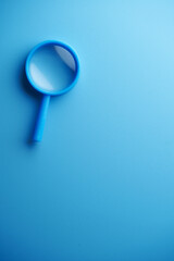 small magnifying glass against blue background