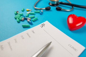 blank doctor's prescription. A stethoscope and a red heart are also on a blue background.
