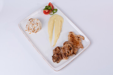 Top view shot of grilled chicken, mashed potatoes, salad and rice pilaf on white background in isolated setting.
