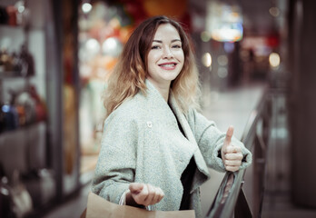 Portrait of attractive curly haired woman with shopping bags in mall
