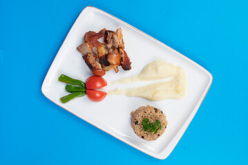 Top view shot of chicken tandoori, mashed potatoes, salad and bulgur pilaf on isolated blue background.
