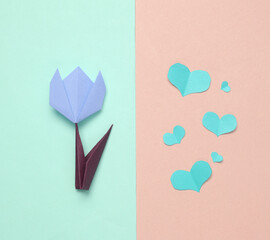 Handmade origami paper tulip and paper cut hearts.on colored background. 8 March or mother's day concept. Top view. Minimalism