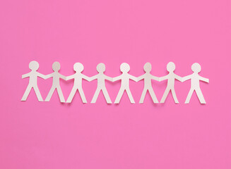 Cut paper human chain hold hands and show their unity on pink background. Solidarity and peace