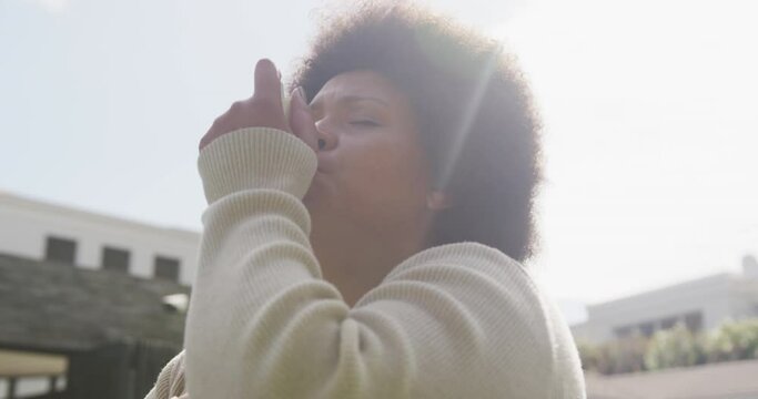Video of plus size african american woman using inhalator outdoors