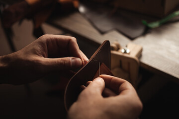 tanner makes leather product, purse. With your own hands, DIY instruction, indoor, closeup,...