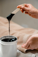 Fototapeta na wymiar a large jar of black depilatory. Black scrub. Black oil for a relaxing close-up massage.