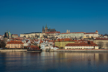 Fototapeta na wymiar Old town of Prague. Czech Republic over the Vltava River with St. Vitus Cathedral on the horizon. Bright sunny day blue sky.