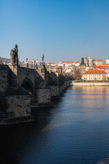 Beautiful view of the Charles Bridge in Prague, Czech Republic at the end of March. Cold sunny spring.