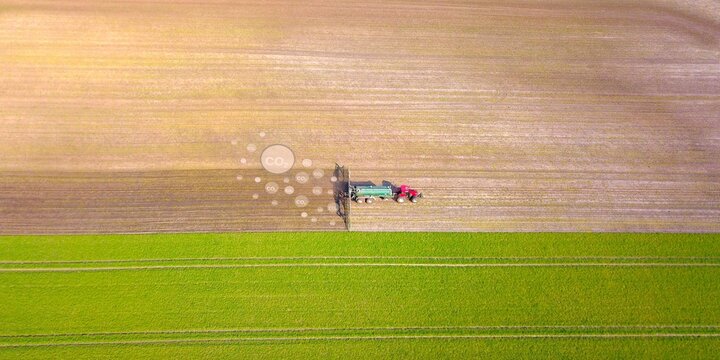 Traktor mit G&uuml;llefass und Schelppschuhverteiler verteilt G&uuml;lle auf Acker, dahinter illustrierte CO2 Blasen, Emissionen aus der Landwirtschaft, Umwelt, Klimawandel, Klimaschutz