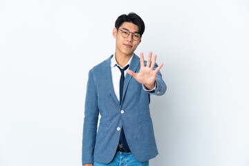 Young Chinese business man isolated on white background counting five with fingers