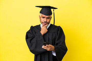 Young university graduate Colombian man isolated on yellow background thinking and sending a message