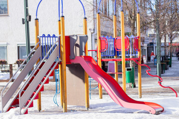 children playground with slide  in winter in european city
